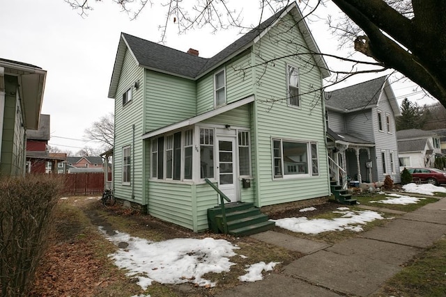 exterior space featuring a chimney, entry steps, and fence