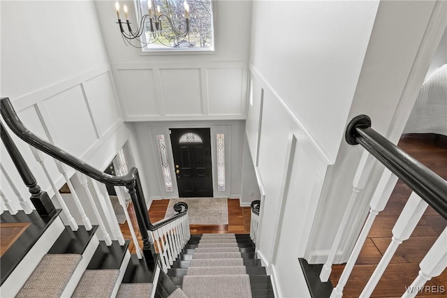 4369 Autumn Ln, Lewiston, NY 14092 - entrance foyer with stairs, a decorative wall, wood finished floors, and a notable chandelier