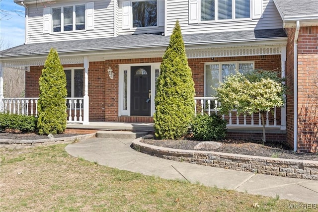 4369 Autumn Ln, Lewiston, NY 14092 - view of exterior entry with brick siding, a shingled roof, and a porch