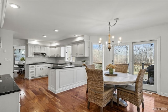 4369 Autumn Ln, Lewiston, NY 14092 - kitchen with dark countertops, an inviting chandelier, tasteful backsplash, and dark wood finished floors