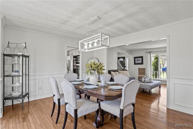 4369 Autumn Ln, Lewiston, NY 14092 - dining area featuring crown molding, stairs, a textured ceiling, a decorative wall, and wood finished floors