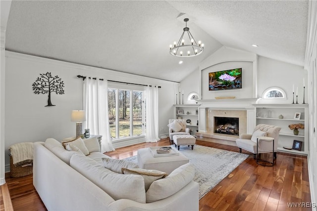 4369 Autumn Ln, Lewiston, NY 14092 - living room featuring a textured ceiling, a fireplace, lofted ceiling, dark wood-style floors, and a notable chandelier