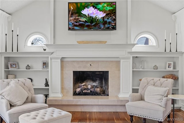 4369 Autumn Ln, Lewiston, NY 14092 - living room featuring vaulted ceiling, wood finished floors, a tile fireplace, and built in shelves