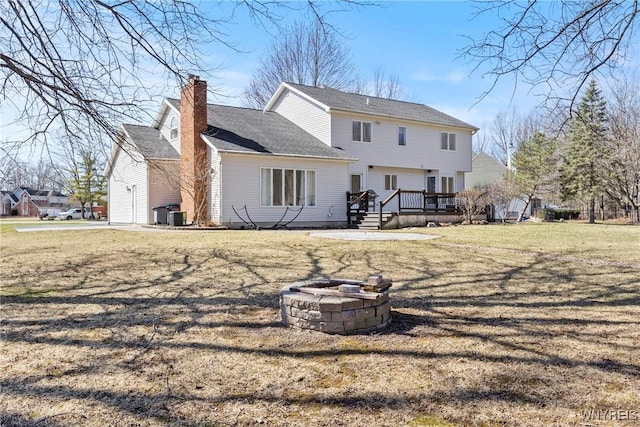 4369 Autumn Ln, Lewiston, NY 14092 - back of house with a chimney, roof with shingles, a deck, a fire pit, and a lawn