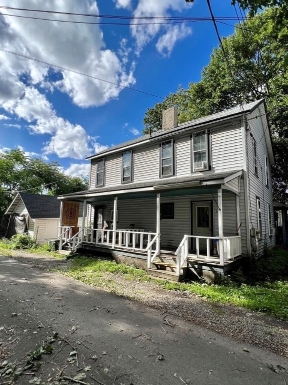 view of front facade with a porch and a chimney