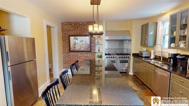 kitchen featuring wall chimney range hood, a center island, a sink, dark stone countertops, and stainless steel appliances
