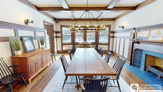 dining space with an inviting chandelier, beam ceiling, coffered ceiling, and wood finished floors