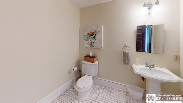 bathroom with baseboards and toilet
