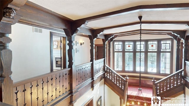 hall featuring visible vents and lofted ceiling with beams