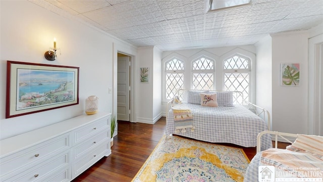 bedroom with baseboards, multiple windows, and dark wood-style floors