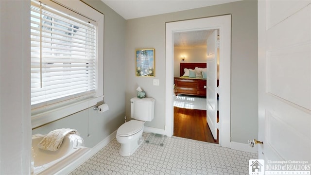 bathroom featuring baseboards and toilet