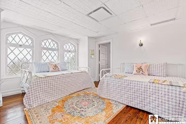 bedroom with baseboards and wood finished floors