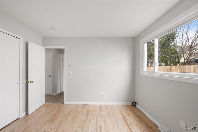unfurnished bedroom with baseboards, visible vents, and wood finished floors