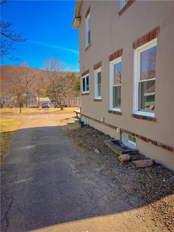 1230 Lake St, Elmira-City, NY 14901 - view of side of home featuring stucco siding and aphalt driveway