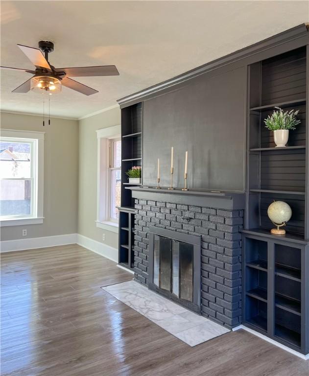 1230 Lake St, Elmira-City, NY 14901 - unfurnished living room featuring baseboards, a fireplace, wood finished floors, ceiling fan, and ornamental molding