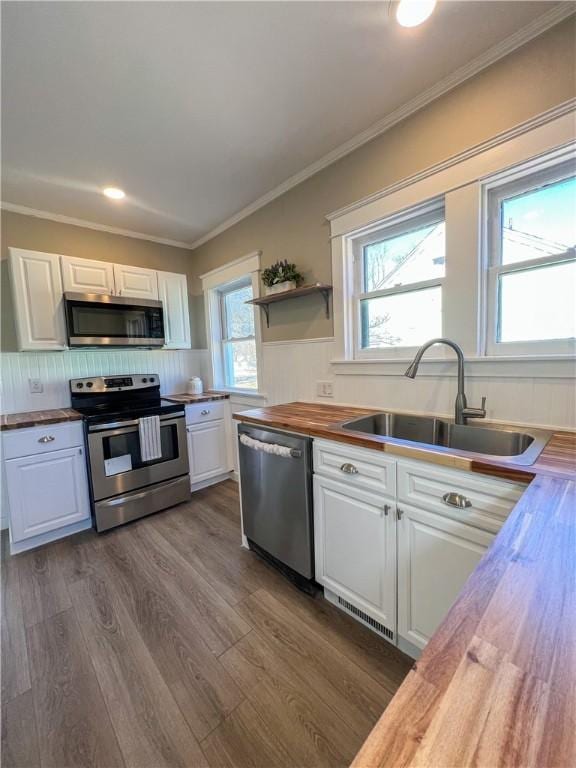 1230 Lake St, Elmira-City, NY 14901 - kitchen with ornamental molding, wooden counters, a sink, white cabinets, and appliances with stainless steel finishes