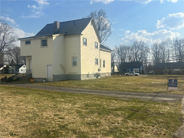 140 Riverside Dr, Utica, NY 13502 - view of home's exterior with a lawn, a metal roof, and a chimney