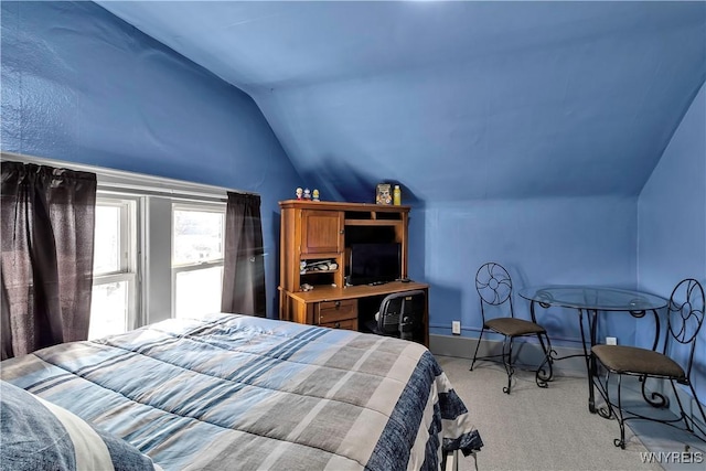 bedroom with light colored carpet and vaulted ceiling