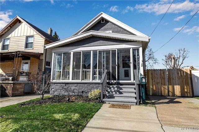 view of front facade with fence and a sunroom