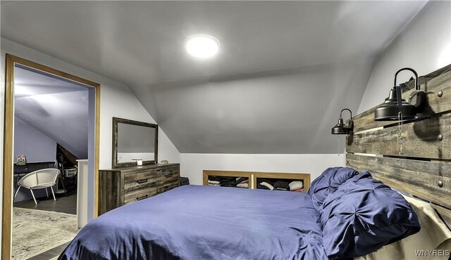 bedroom with wood finished floors and vaulted ceiling