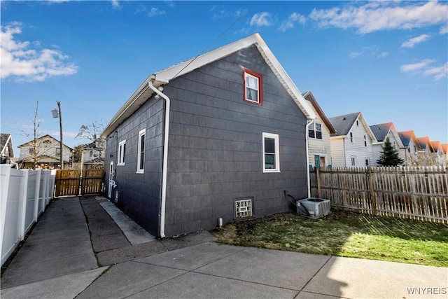 view of property exterior with a fenced backyard, a patio area, and a residential view
