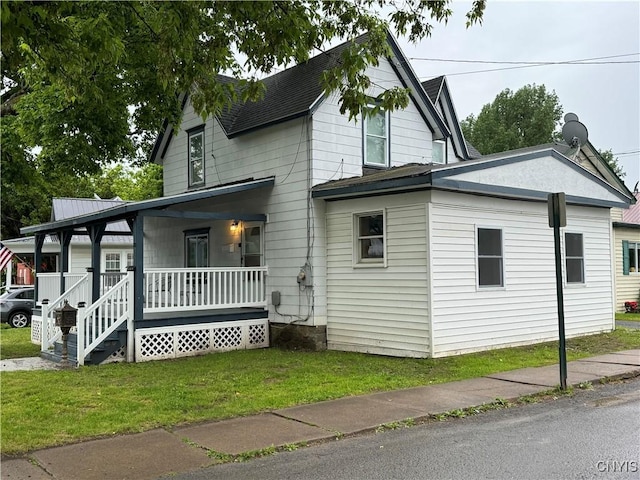view of home's exterior featuring a shingled roof, a porch, and a yard