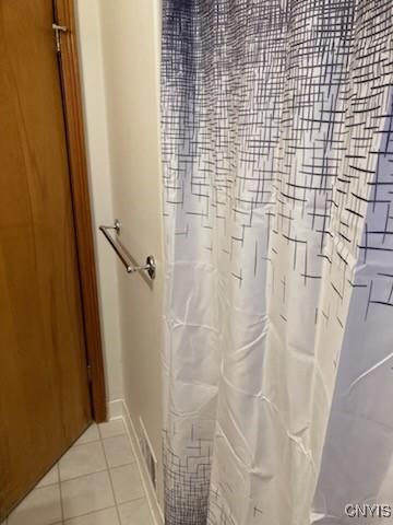 bathroom with baseboards, a shower with curtain, and tile patterned flooring