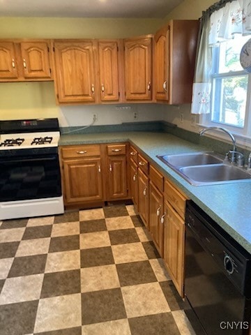kitchen featuring light floors, dishwasher, gas stove, and a sink