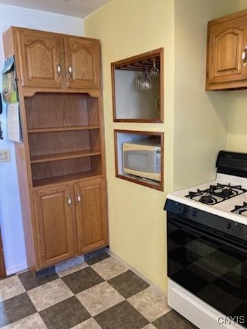 kitchen featuring brown cabinetry, white appliances, and light countertops