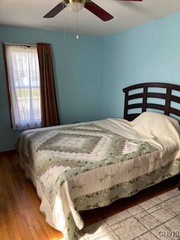 bedroom with a ceiling fan and wood finished floors