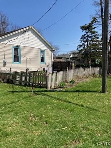 view of property exterior with a lawn and fence