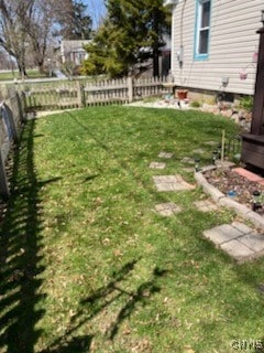 view of yard featuring a fenced backyard and a garden