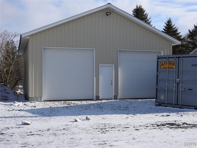 snow covered garage featuring a garage