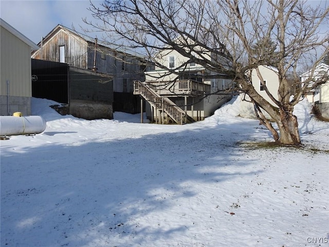 snowy yard featuring stairway