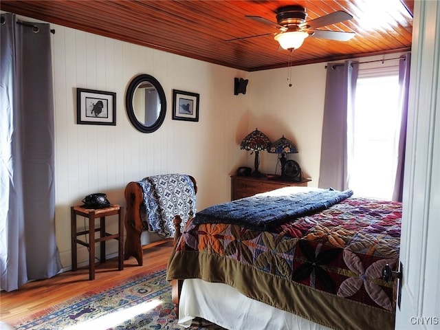 bedroom with a ceiling fan, wood finished floors, and wood ceiling