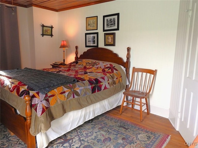 bedroom featuring wood finished floors and crown molding