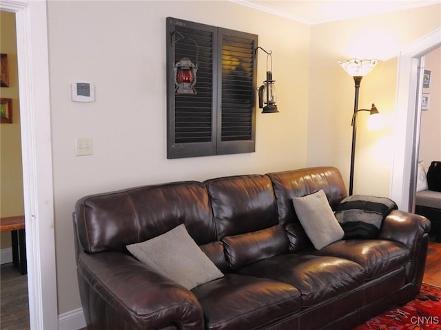 living room featuring baseboards, ornamental molding, and wood finished floors