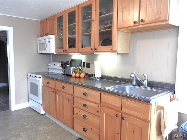 kitchen with white appliances, baseboards, a sink, dark countertops, and glass insert cabinets