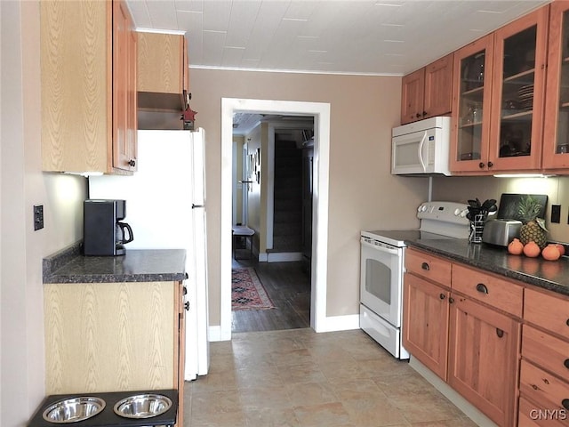 kitchen featuring baseboards, glass insert cabinets, brown cabinetry, and white appliances