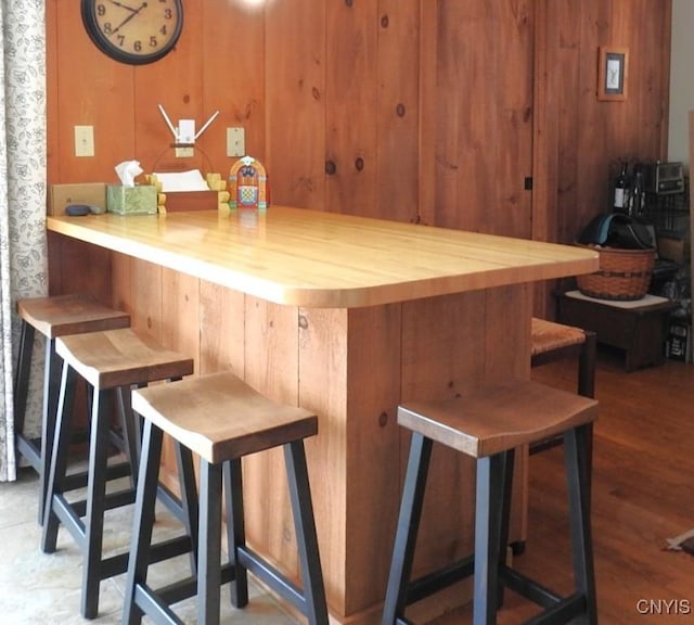 bar with wood walls and wood finished floors