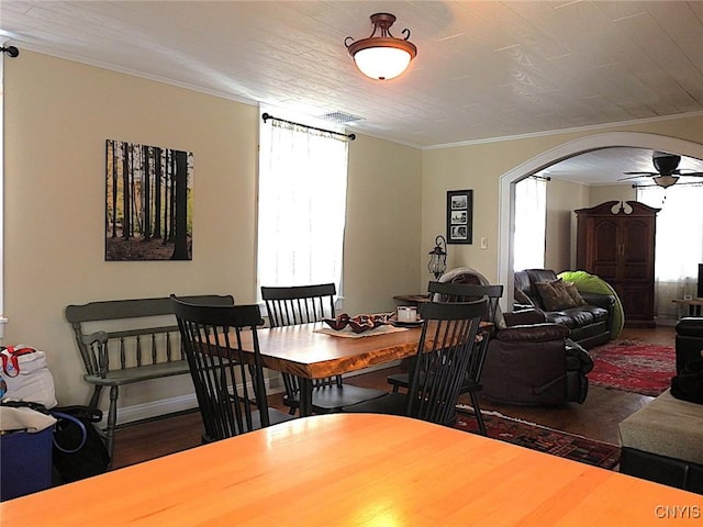 dining room featuring a ceiling fan, arched walkways, crown molding, and visible vents
