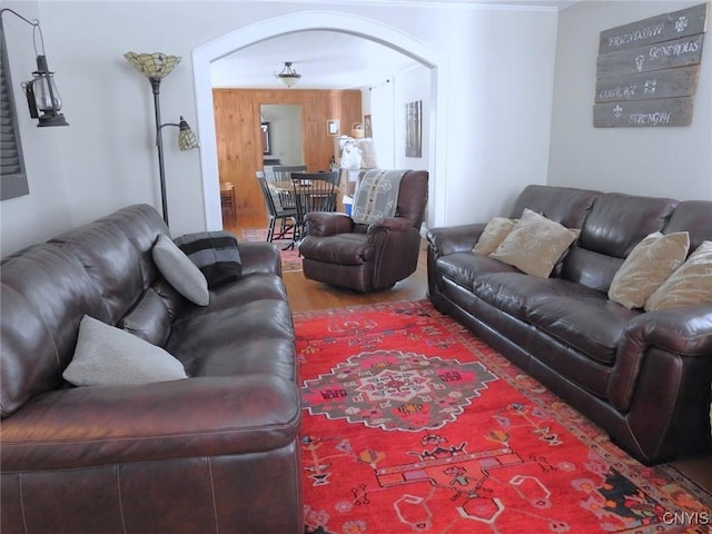 living area with arched walkways and wood finished floors