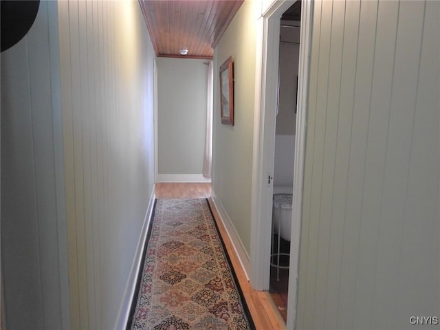 hallway with wooden ceiling, baseboards, and wood finished floors