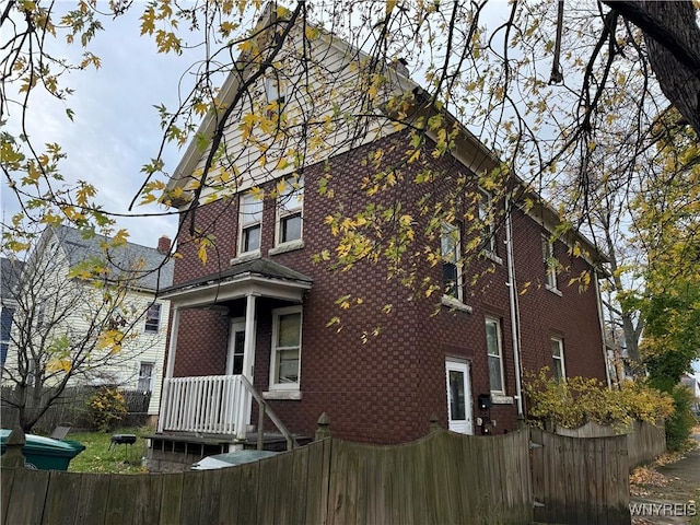 view of side of home with brick siding and a fenced front yard