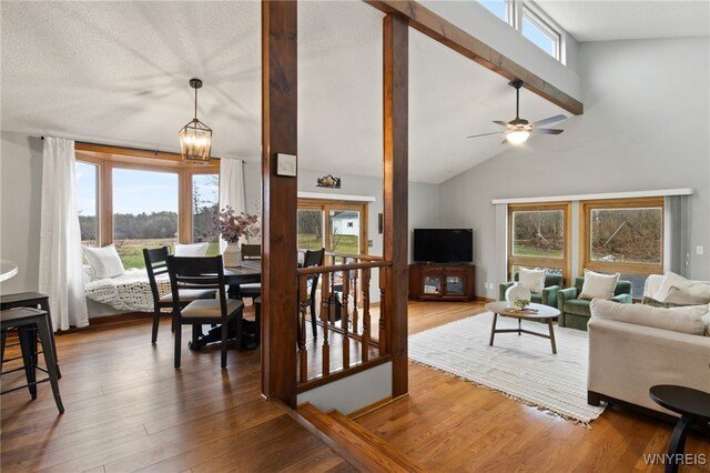 6741 Cole Rd, Orchard Park, NY 14127 - living area featuring ceiling fan with notable chandelier, beamed ceiling, high vaulted ceiling, and wood finished floors
