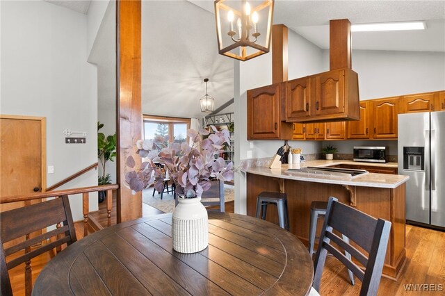6741 Cole Rd, Orchard Park, NY 14127 - dining room with light wood finished floors, high vaulted ceiling, and a chandelier