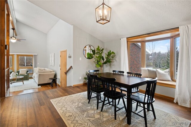 6741 Cole Rd, Orchard Park, NY 14127 - dining room featuring baseboards, vaulted ceiling, ceiling fan with notable chandelier, and hardwood / wood-style floors