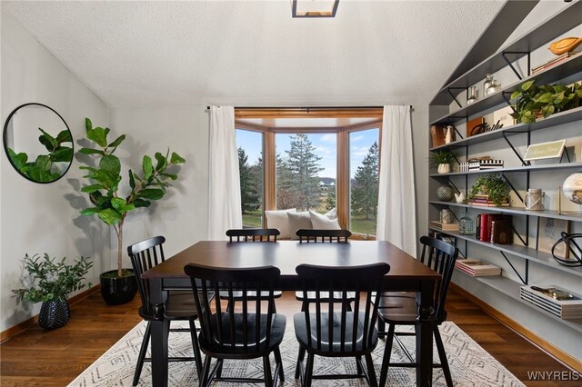 6741 Cole Rd, Orchard Park, NY 14127 - dining area featuring a textured ceiling, baseboards, lofted ceiling, and wood finished floors