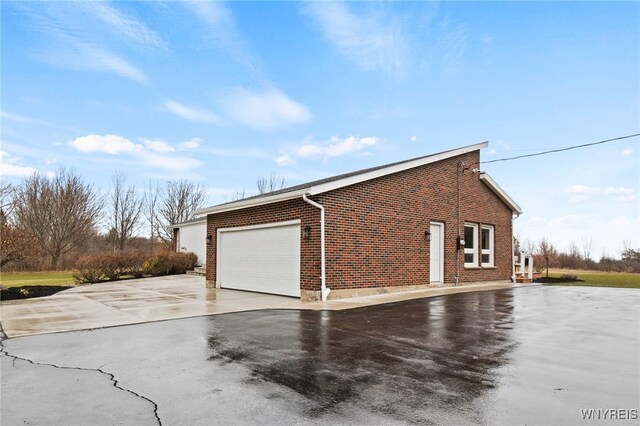 6741 Cole Rd, Orchard Park, NY 14127 - view of side of home featuring driveway, brick siding, and a garage