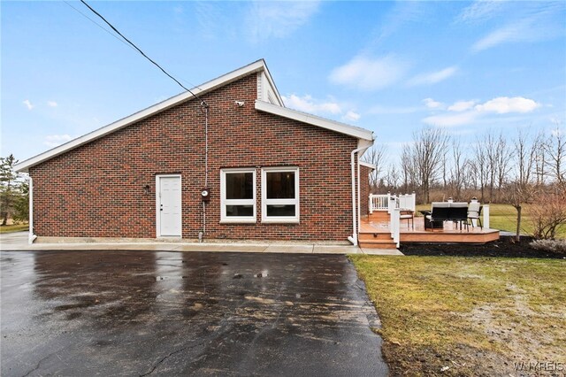 6741 Cole Rd, Orchard Park, NY 14127 - view of home's exterior featuring brick siding, a lawn, and a wooden deck